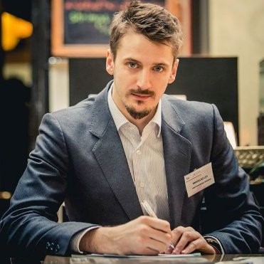 Mężczyzna w garniturze przy biurku podczas konferencji biznesowej