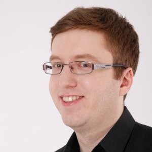 Młody mężczyzna w okularach i czarnej koszuli, portret headshot na białym tle